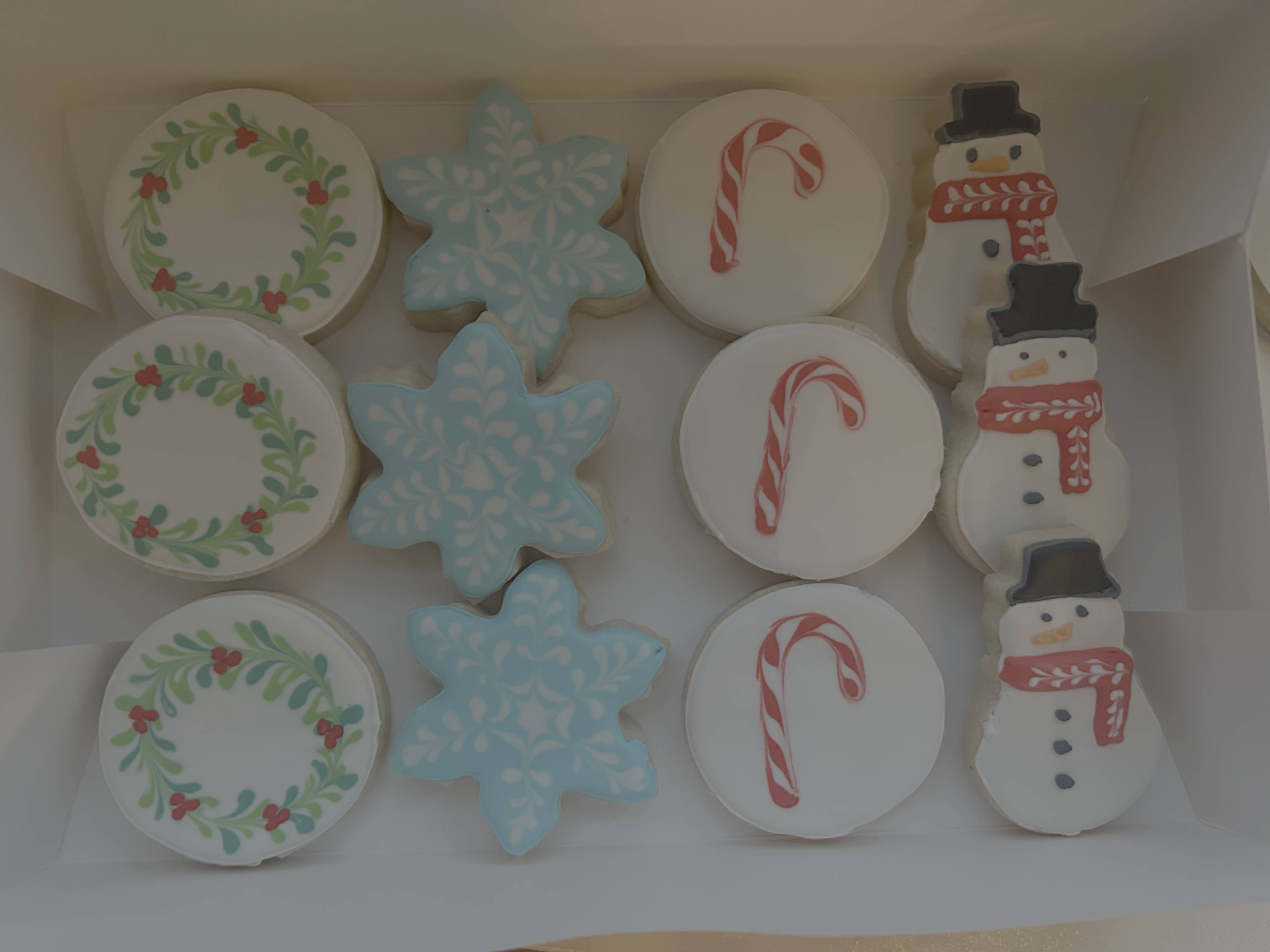 Christmas themed sugar cookies with wreaths, snowflakes, candy canes and snowmen
